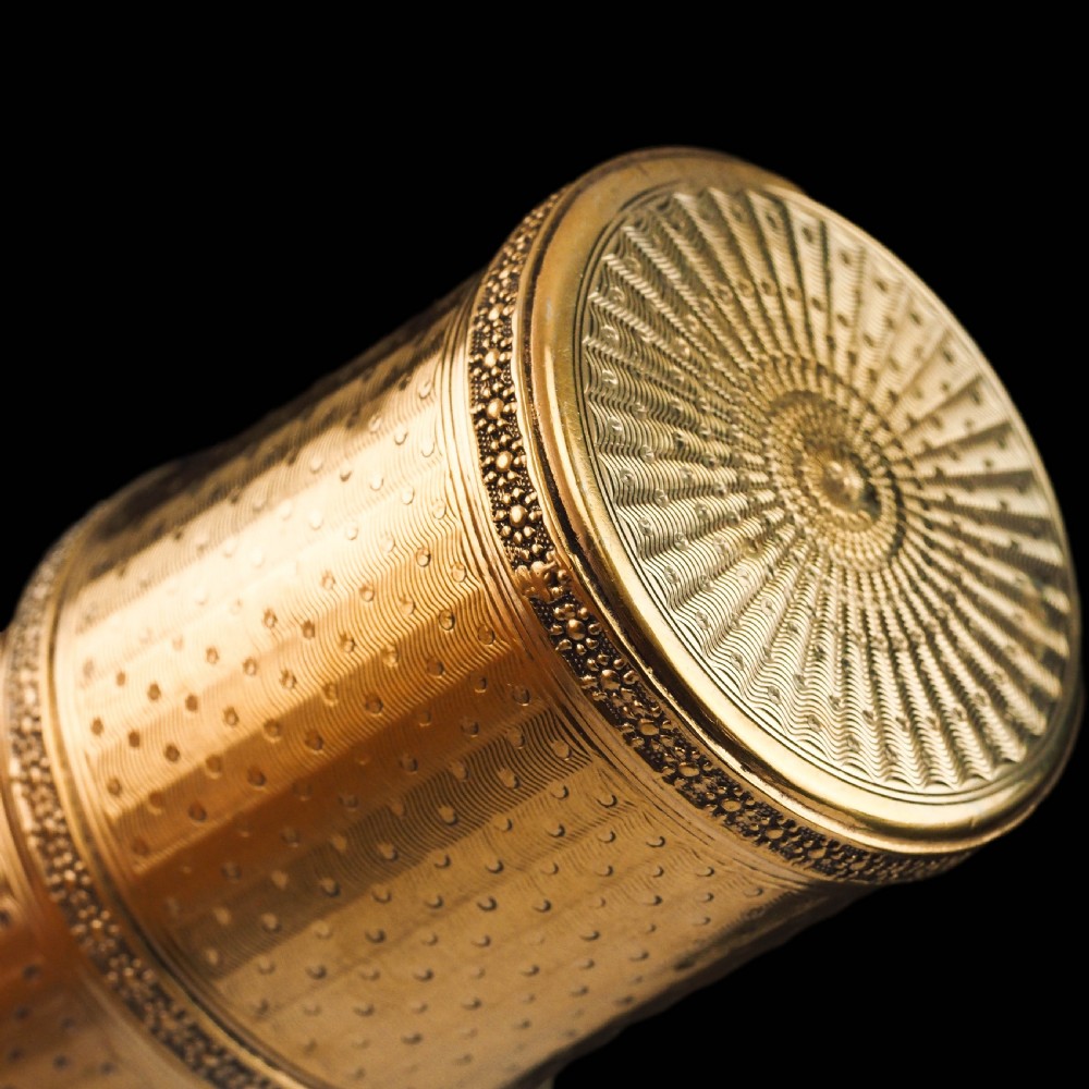 A small cylindrical French silver gilt etui featuring intricate engine-turned guilloche wave patterns and textured borders. View X