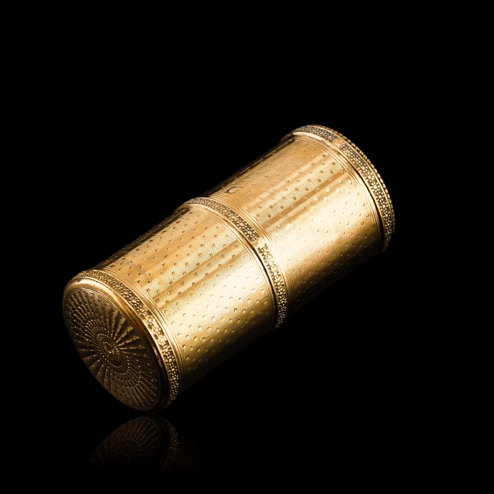 A small cylindrical French silver gilt etui featuring intricate engine-turned guilloche wave patterns and textured borders. View XIX