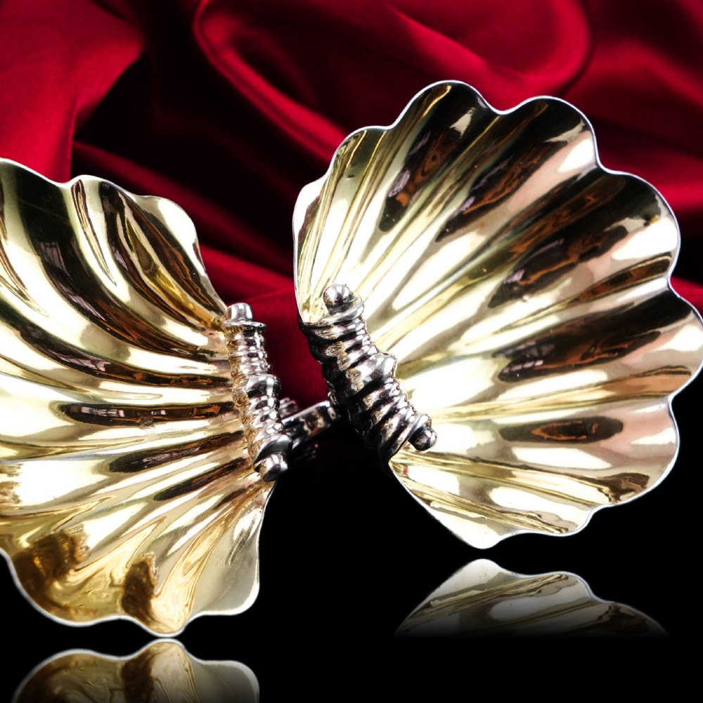 A pair of Georgian sterling silver salt cellars shaped like fluted scallop shells with gilt interiors. View VI