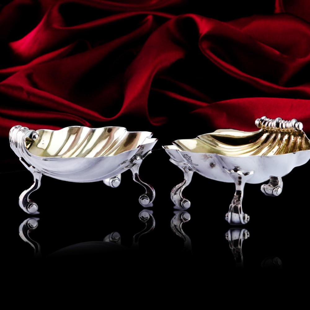 A pair of Georgian sterling silver salt cellars shaped like fluted scallop shells with gilt interiors. View XIV