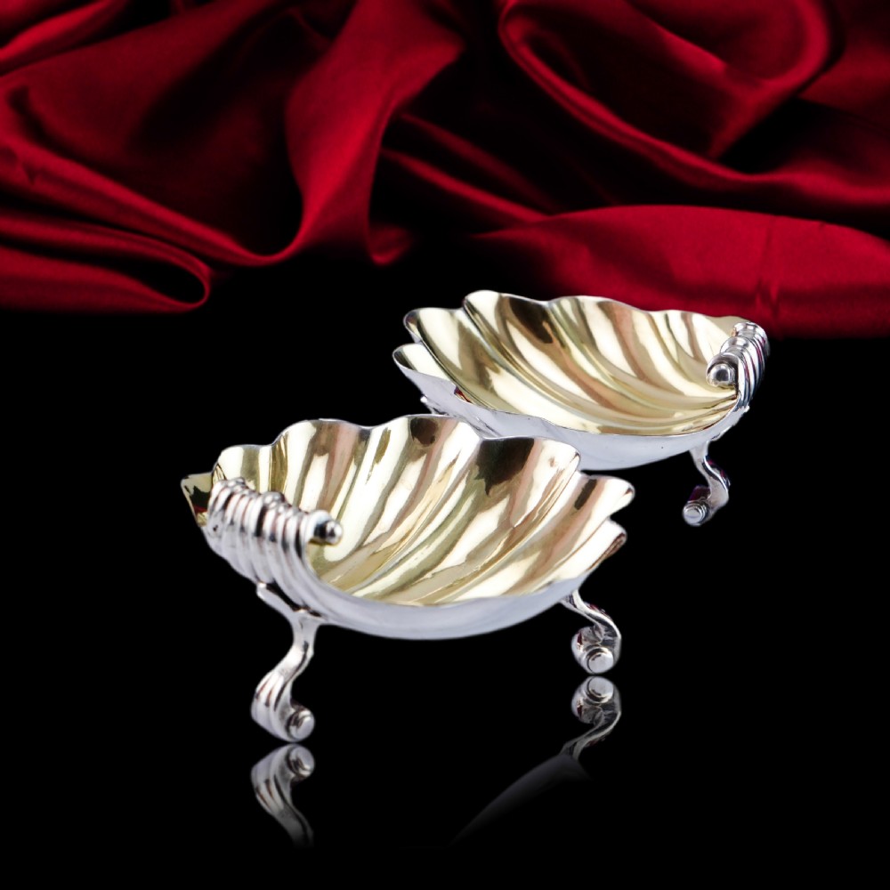 A pair of Georgian sterling silver salt cellars shaped like fluted scallop shells with gilt interiors. View XVI