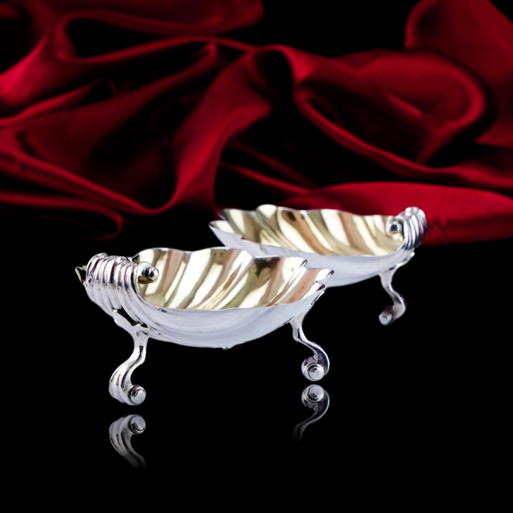 A pair of Georgian sterling silver salt cellars shaped like fluted scallop shells with gilt interiors. View XVII