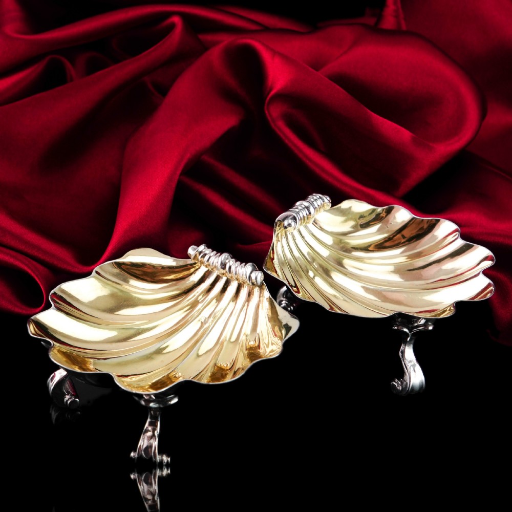 A pair of Georgian sterling silver salt cellars shaped like fluted scallop shells with gilt interiors. View XXI
