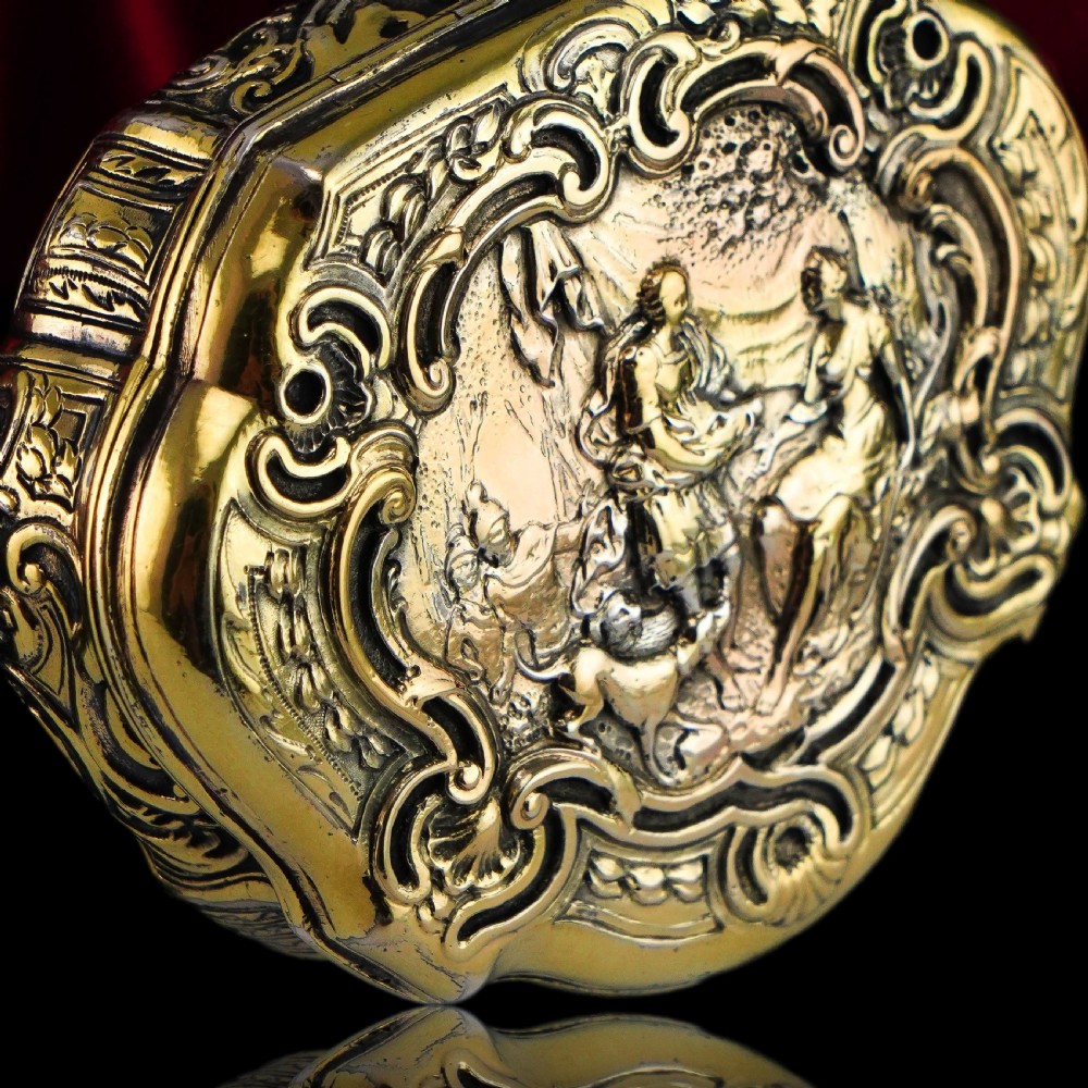 An eighteenth-century shaped oval silver-gilt table snuff box featuring Rococo scrollwork and a raised mythological scene on the hinged lid. View III