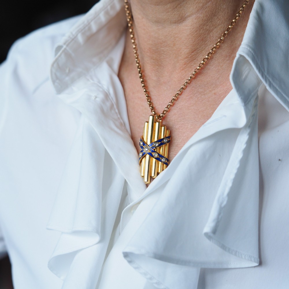A Victorian 18K yellow gold pendant featuring vertical fluted bars encased by blue enamel cross-bands set with rose-cut diamonds. View VII