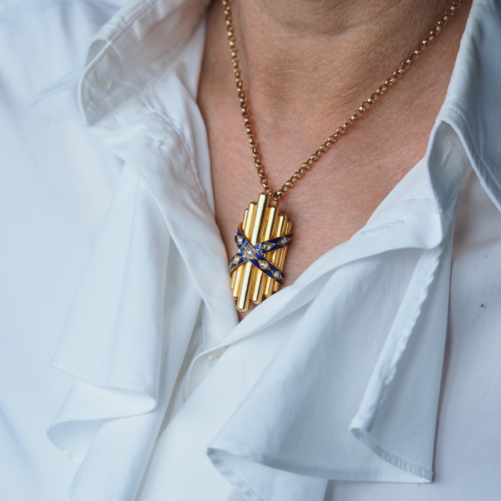 A Victorian 18K yellow gold pendant featuring vertical fluted bars encased by blue enamel cross-bands set with rose-cut diamonds. View VIII