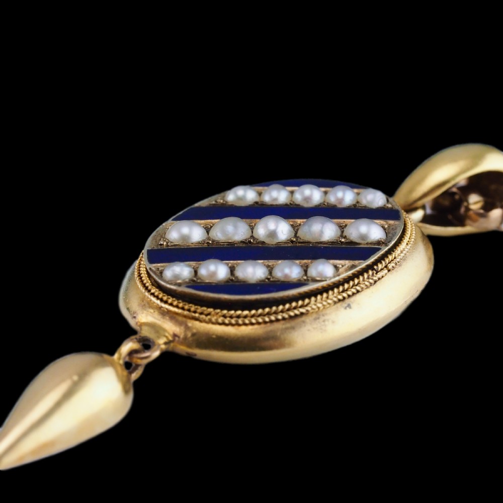 A Victorian 15ct gold oval pendant featuring diagonal stripes of royal blue enamel and seed pearls with a suspended gold drop. View II