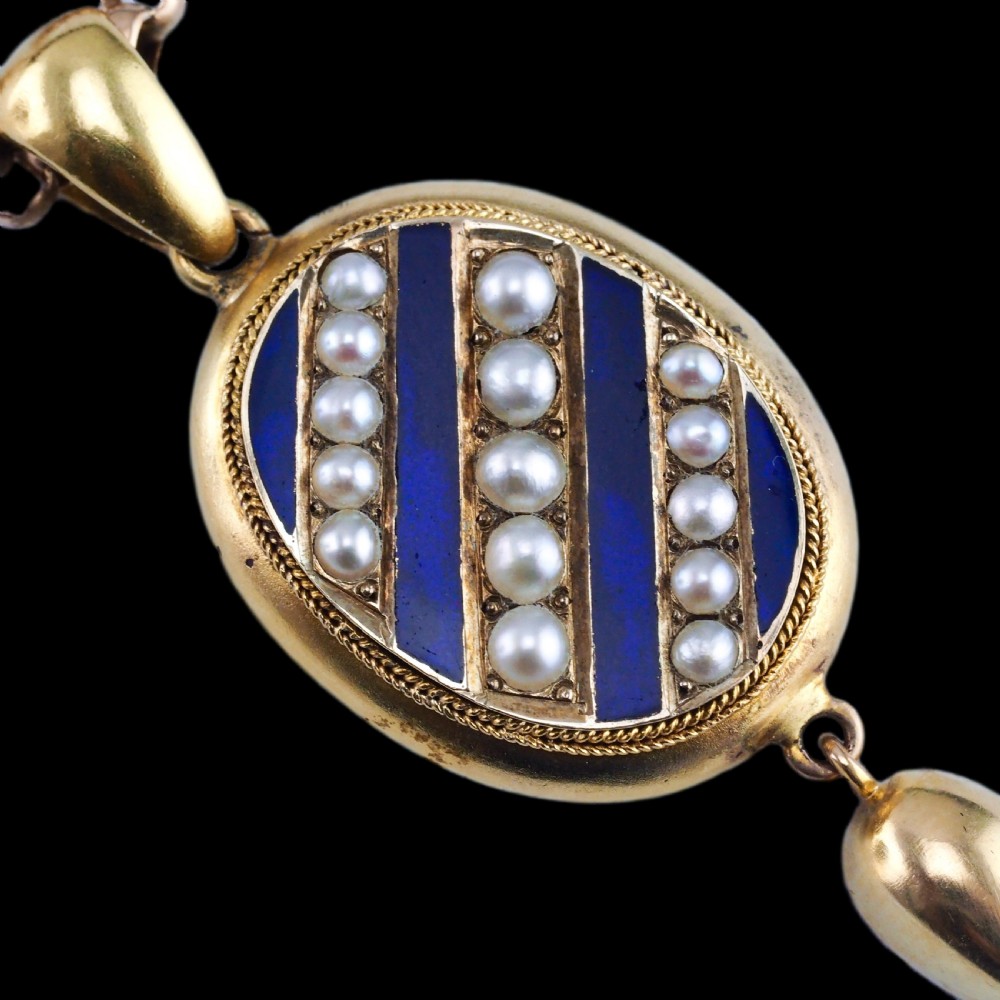 A Victorian 15ct gold oval pendant featuring diagonal stripes of royal blue enamel and seed pearls with a suspended gold drop. View III
