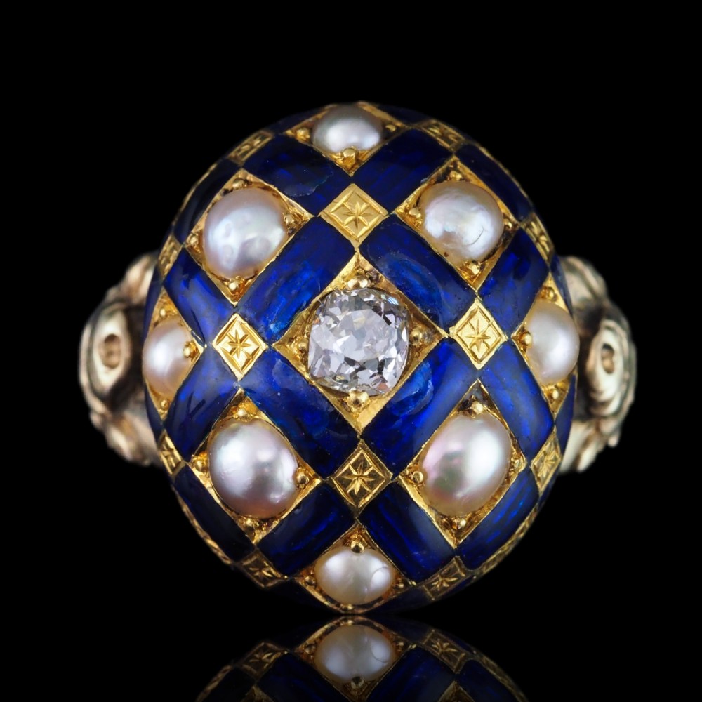 An antique Victorian 14K gold ring featuring a domed royal blue enamel lattice design accented with round pearls, star engravings, and a central diamond.