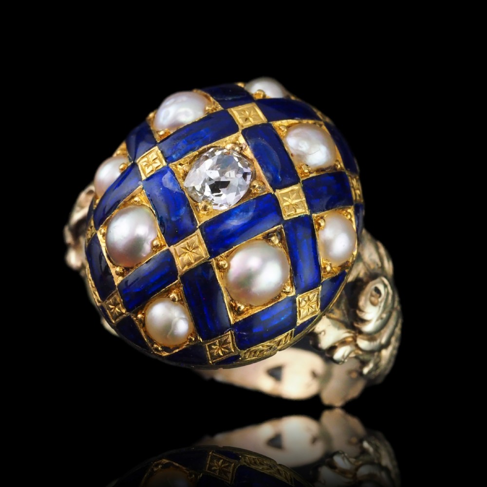 An antique Victorian 14K gold ring featuring a domed royal blue enamel lattice design accented with round pearls, star engravings, and a central diamond. View V