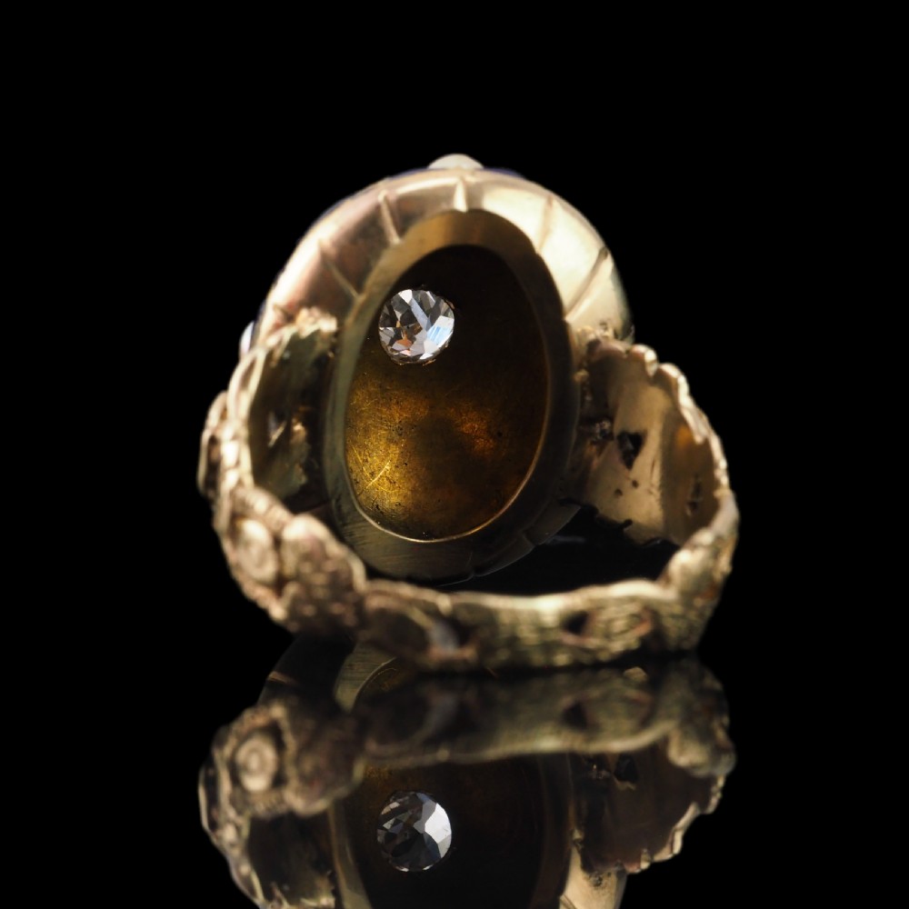 An antique Victorian 14K gold ring featuring a domed royal blue enamel lattice design accented with round pearls, star engravings, and a central diamond. View VII