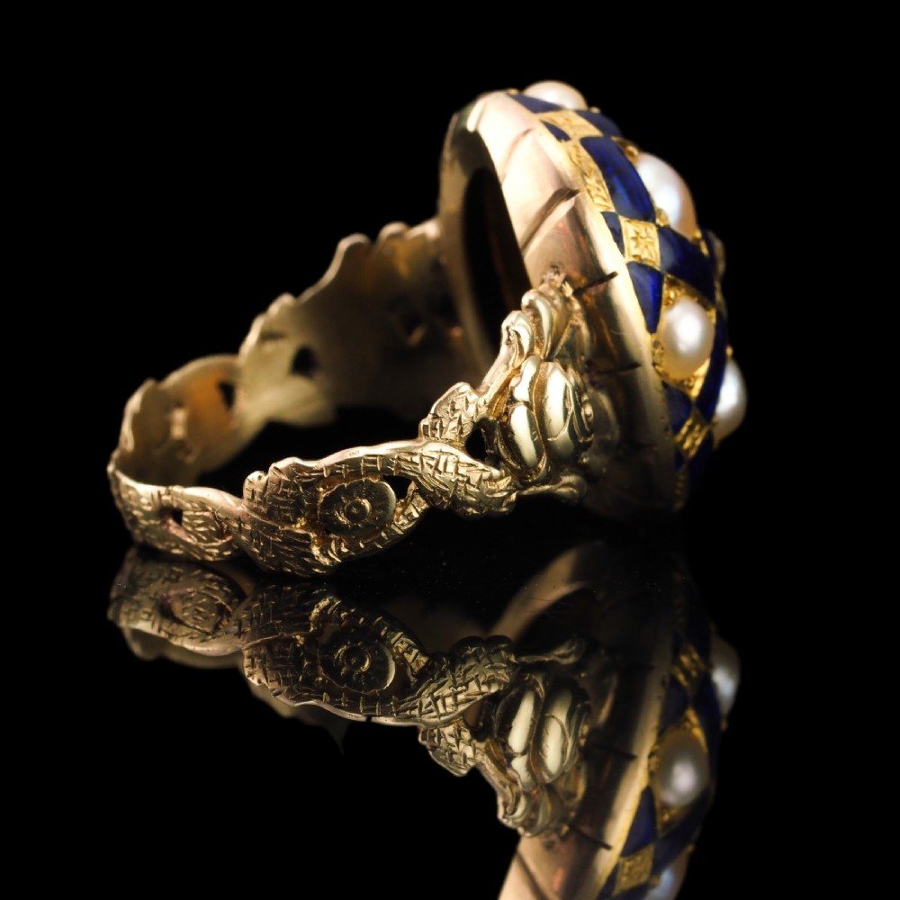 An antique Victorian 14K gold ring featuring a domed royal blue enamel lattice design accented with round pearls, star engravings, and a central diamond. View VIII