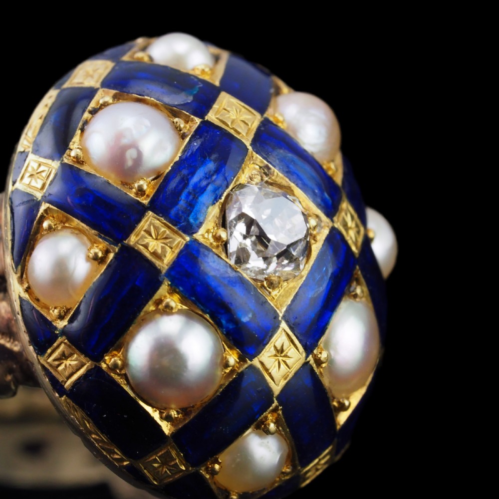 An antique Victorian 14K gold ring featuring a domed royal blue enamel lattice design accented with round pearls, star engravings, and a central diamond. View X