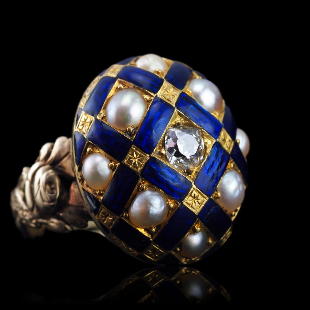 An antique Victorian 14K gold ring featuring a domed royal blue enamel lattice design accented with round pearls, star engravings, and a central diamond. View XII