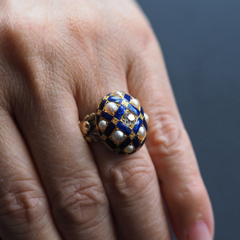 An antique Victorian 14K gold ring featuring a domed royal blue enamel lattice design accented with round pearls, star engravings, and a central diamond. View XIII