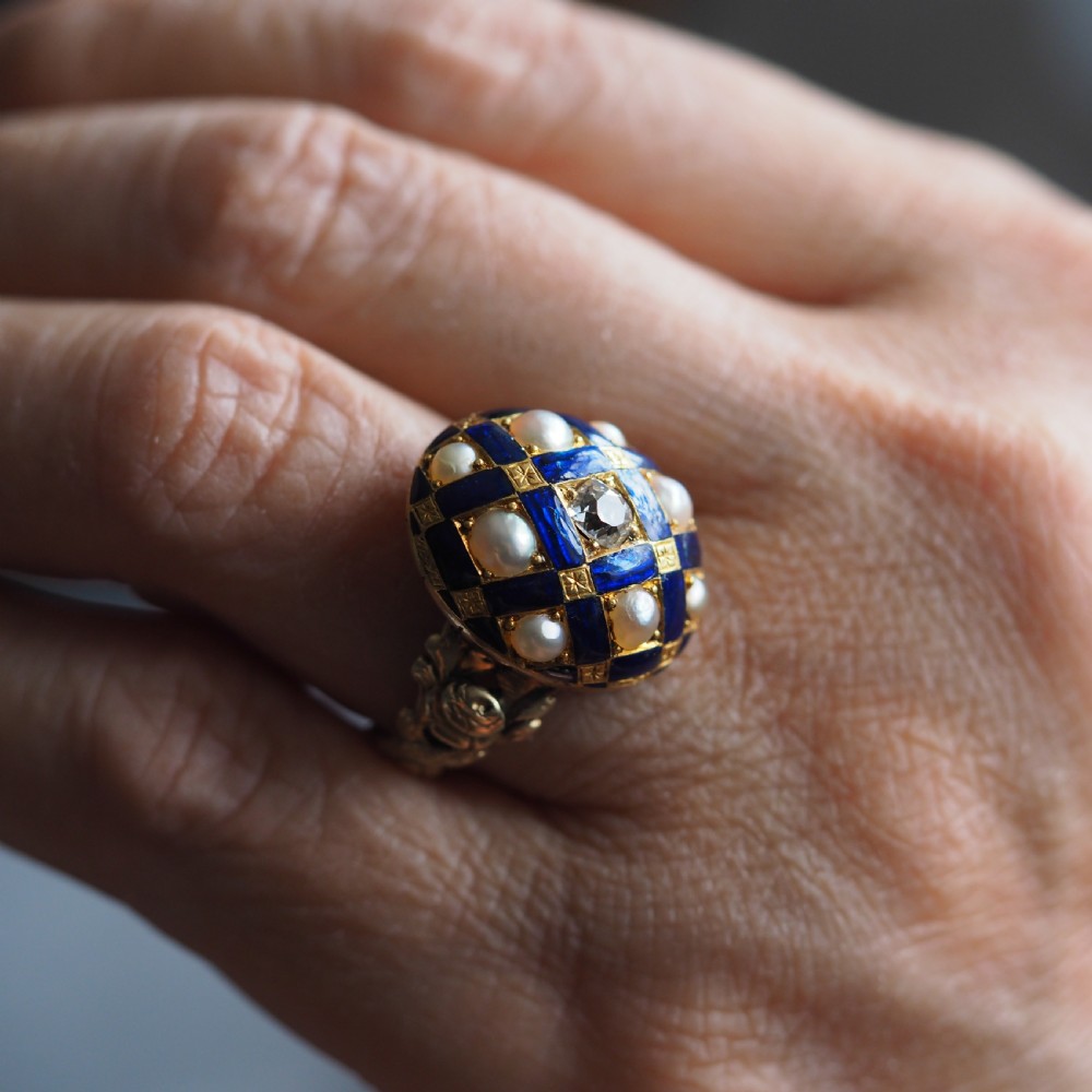 An antique Victorian 14K gold ring featuring a domed royal blue enamel lattice design accented with round pearls, star engravings, and a central diamond. View XIV