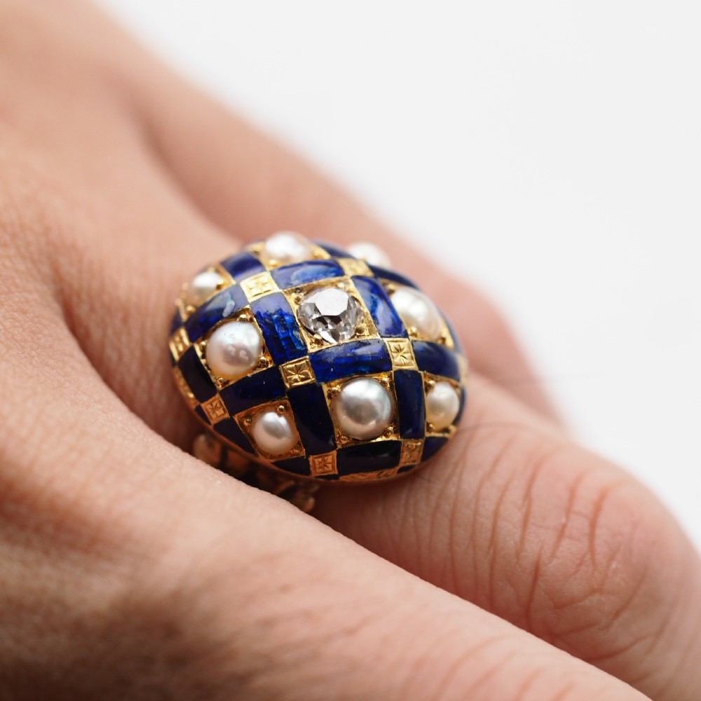 An antique Victorian 14K gold ring featuring a domed royal blue enamel lattice design accented with round pearls, star engravings, and a central diamond. View XVI
