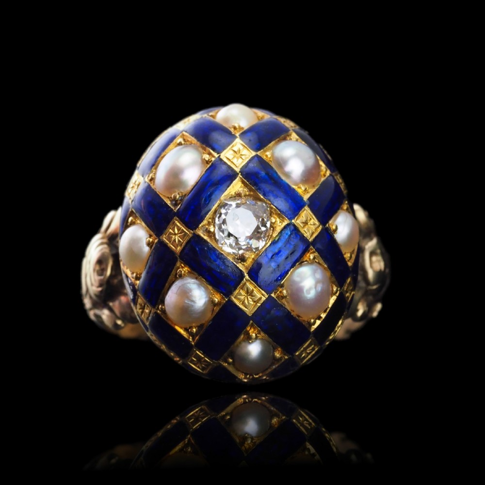 An antique Victorian 14K gold ring featuring a domed royal blue enamel lattice design accented with round pearls, star engravings, and a central diamond. View XXI