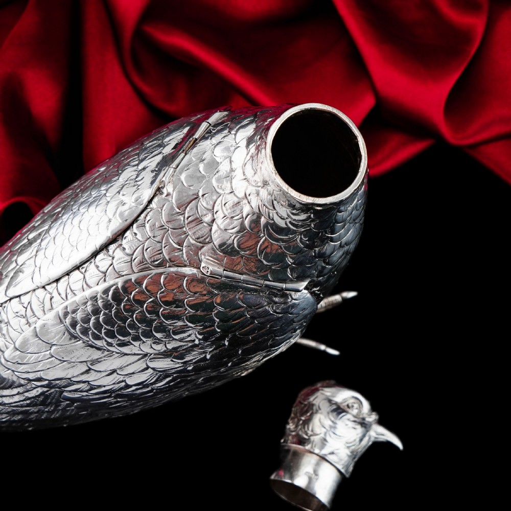 A solid silver model of a partridge with chased feather detailing standing on two feet with a hinged compartment lid along its back. View XXI