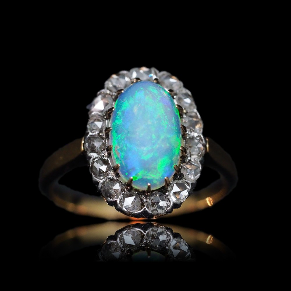 Victorian 18k gold cluster ring featuring an oval cabochon opal surrounded by a halo of rose-cut diamonds. View II