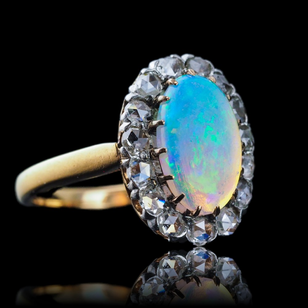 Victorian 18k gold cluster ring featuring an oval cabochon opal surrounded by a halo of rose-cut diamonds. View III