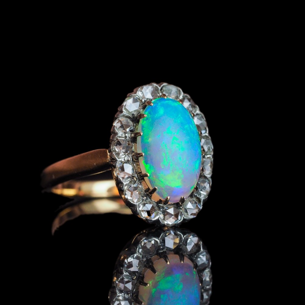 Victorian 18k gold cluster ring featuring an oval cabochon opal surrounded by a halo of rose-cut diamonds. View VII