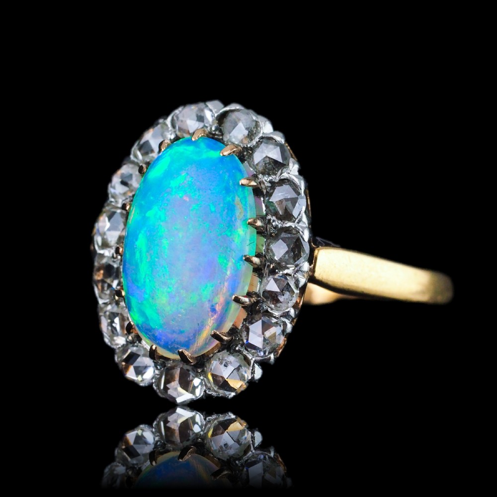 Victorian 18k gold cluster ring featuring an oval cabochon opal surrounded by a halo of rose-cut diamonds. View IX