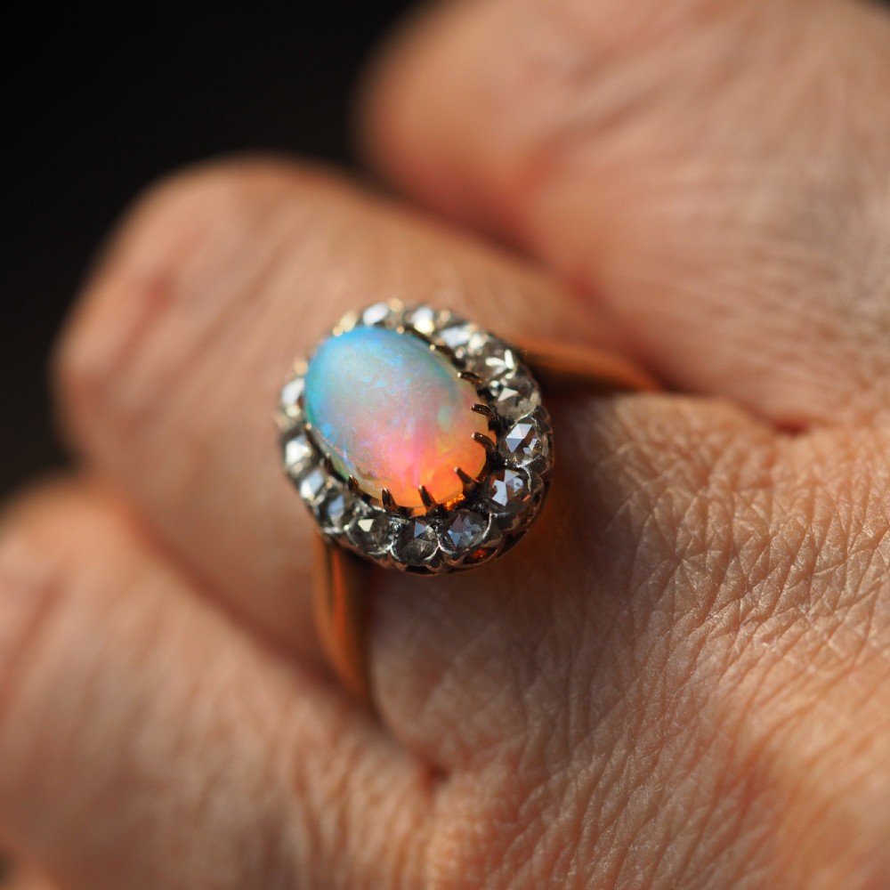 Victorian 18k gold cluster ring featuring an oval cabochon opal surrounded by a halo of rose-cut diamonds. View XI