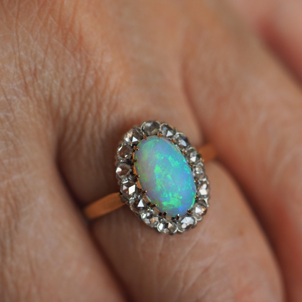 Victorian 18k gold cluster ring featuring an oval cabochon opal surrounded by a halo of rose-cut diamonds. View XIII
