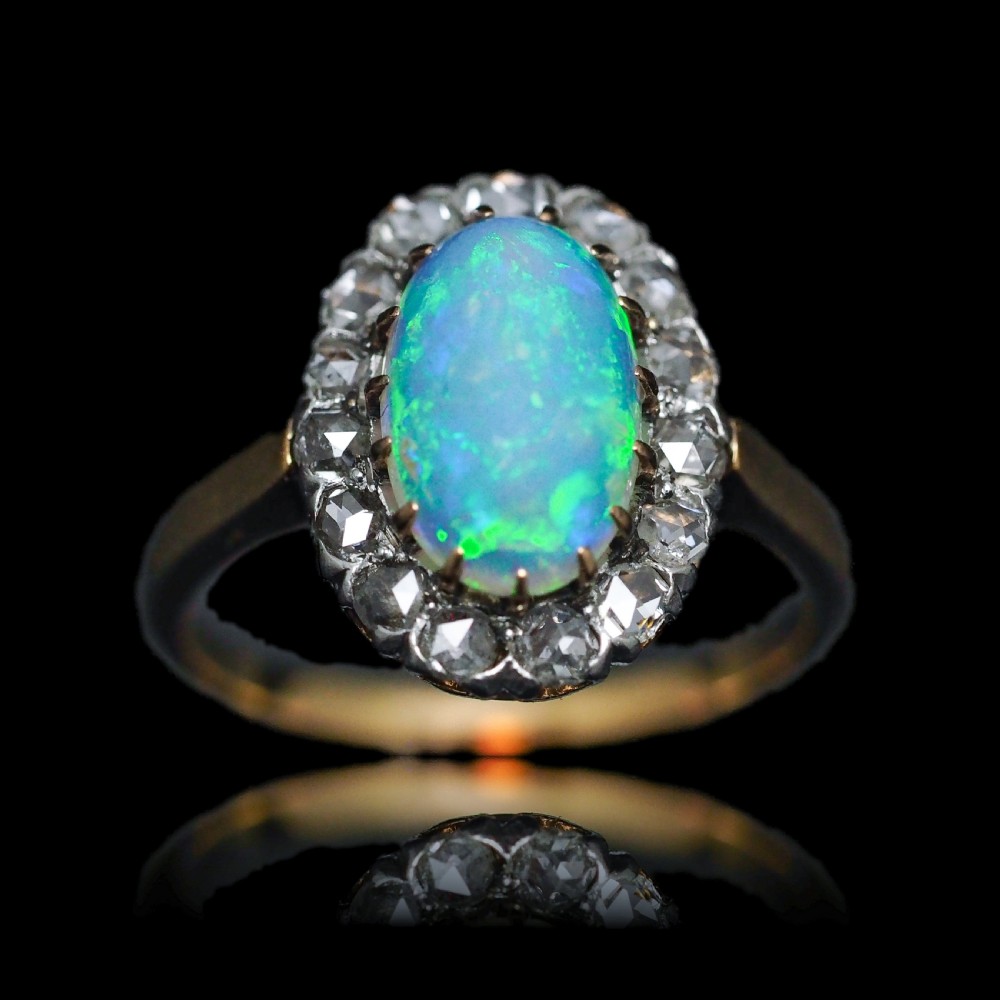 Victorian 18k gold cluster ring featuring an oval cabochon opal surrounded by a halo of rose-cut diamonds. View XX