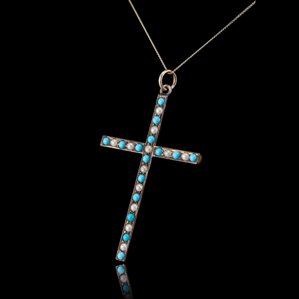 An antique 9ct gold cross pendant set with alternating blue turquoise cabochons and white seed pearls, suspended from a fine gold chain. View II
