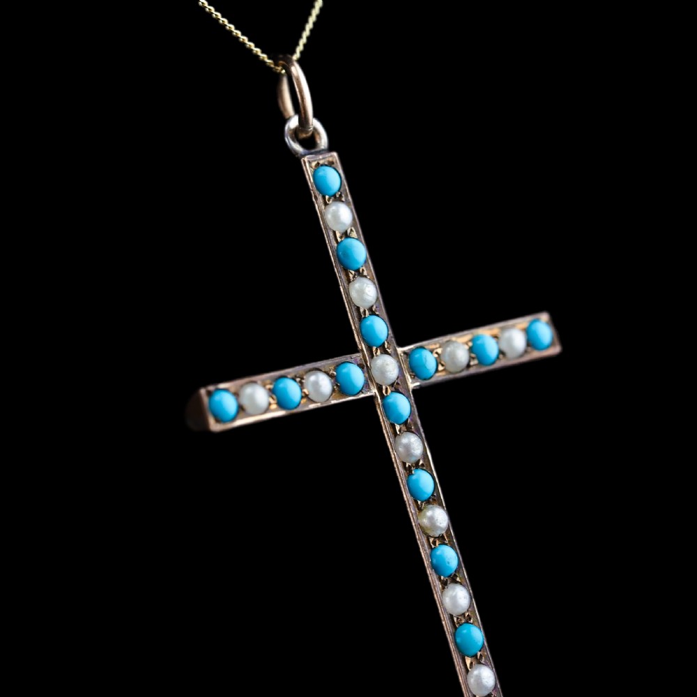 An antique 9ct gold cross pendant set with alternating blue turquoise cabochons and white seed pearls, suspended from a fine gold chain. View V