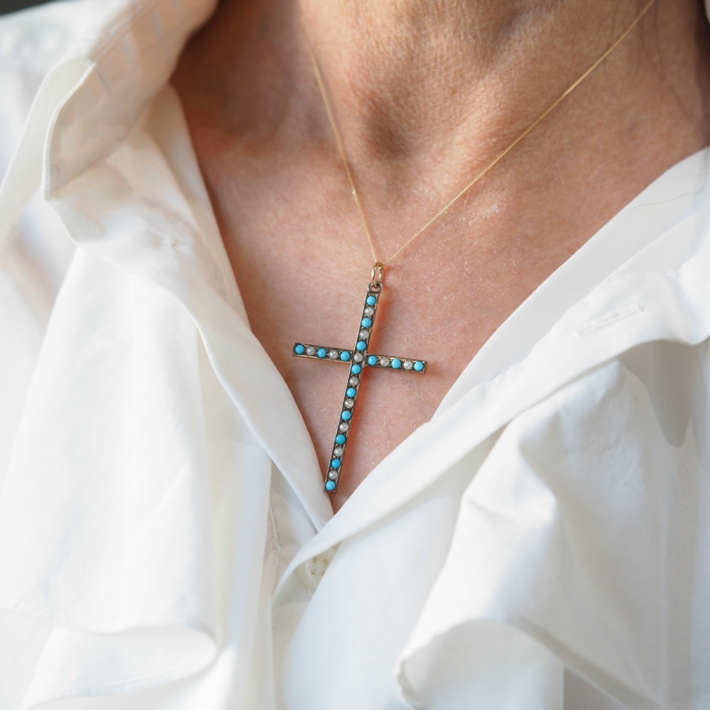 An antique 9ct gold cross pendant set with alternating blue turquoise cabochons and white seed pearls, suspended from a fine gold chain. View VII