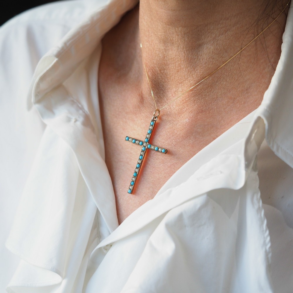 An antique 9ct gold cross pendant set with alternating blue turquoise cabochons and white seed pearls, suspended from a fine gold chain. View VIII