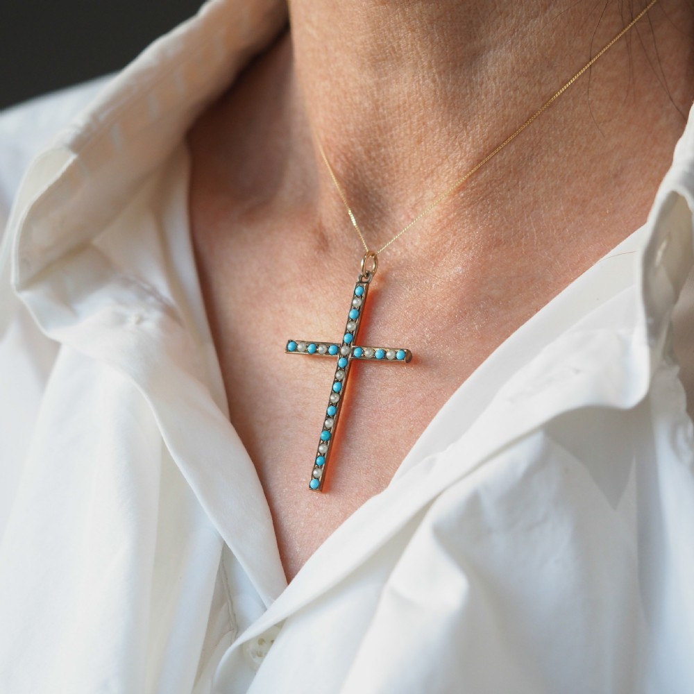 An antique 9ct gold cross pendant set with alternating blue turquoise cabochons and white seed pearls, suspended from a fine gold chain. View IX
