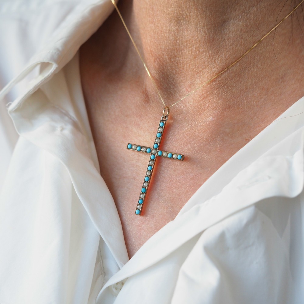 An antique 9ct gold cross pendant set with alternating blue turquoise cabochons and white seed pearls, suspended from a fine gold chain. View X