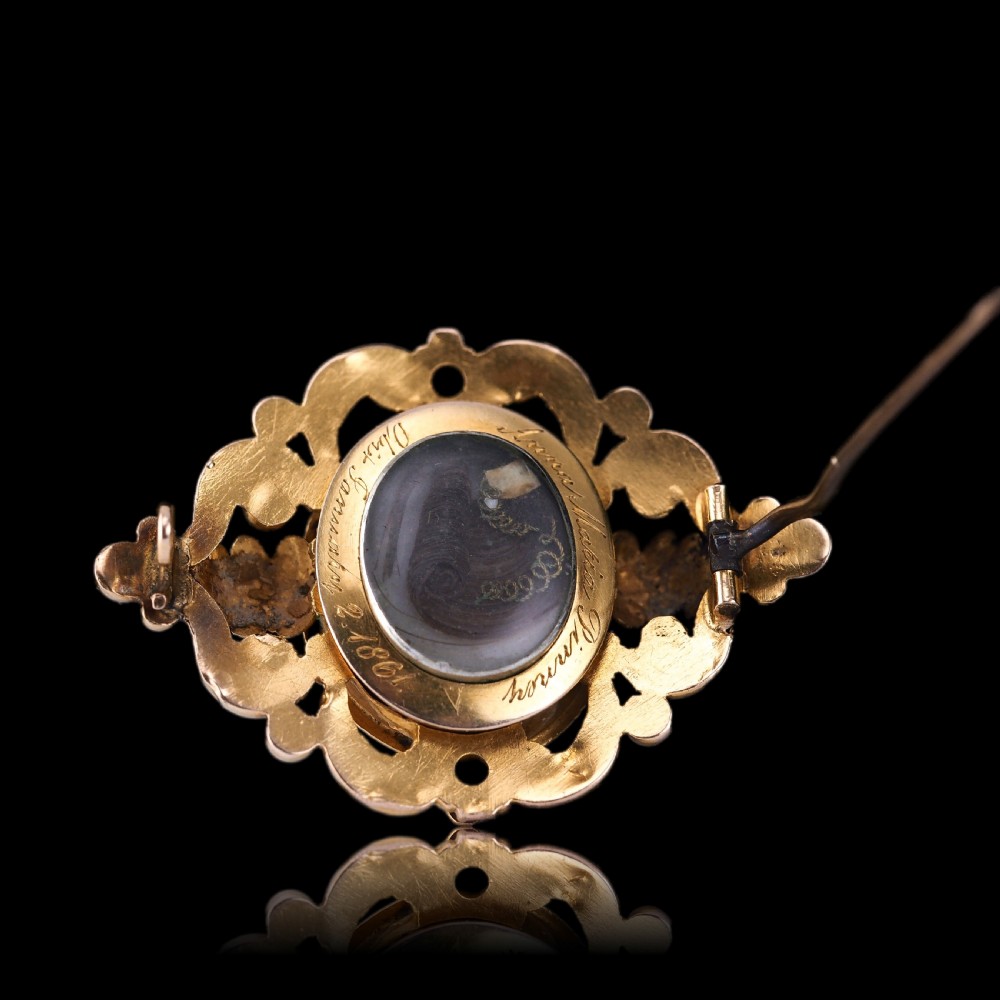 An oval Victorian shell cameo depicting a relief-carved cherub, mounted in an 18ct gold frame with scrollwork and leaf motifs. View XII