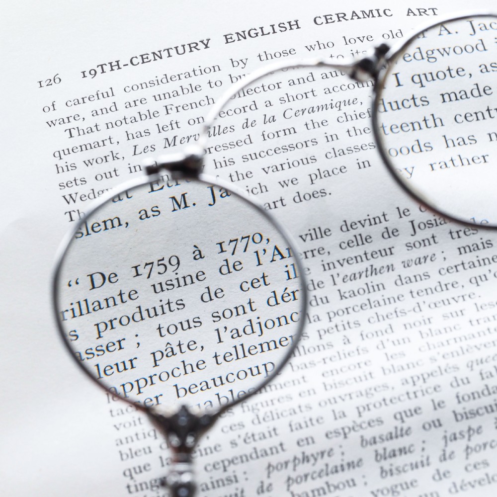 An Art Deco platinum lorgnette featuring a circular folding magnifying glass lens attached to a geometric handle set with small diamonds. View XVII