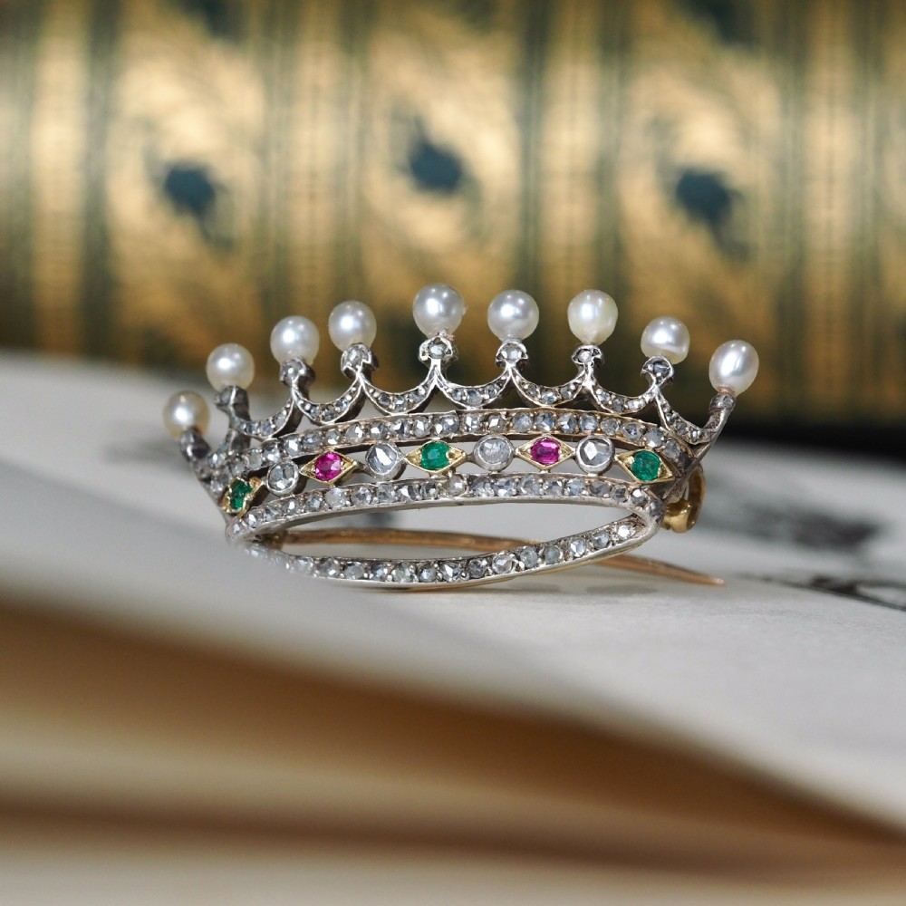 An antique French coronet brooch crafted in 18K gold and silver, encrusted with diamonds, rubies, emeralds, and topped with nine pearls. View II