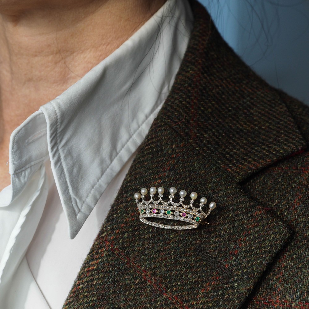 An antique French coronet brooch crafted in 18K gold and silver, encrusted with diamonds, rubies, emeralds, and topped with nine pearls. View V