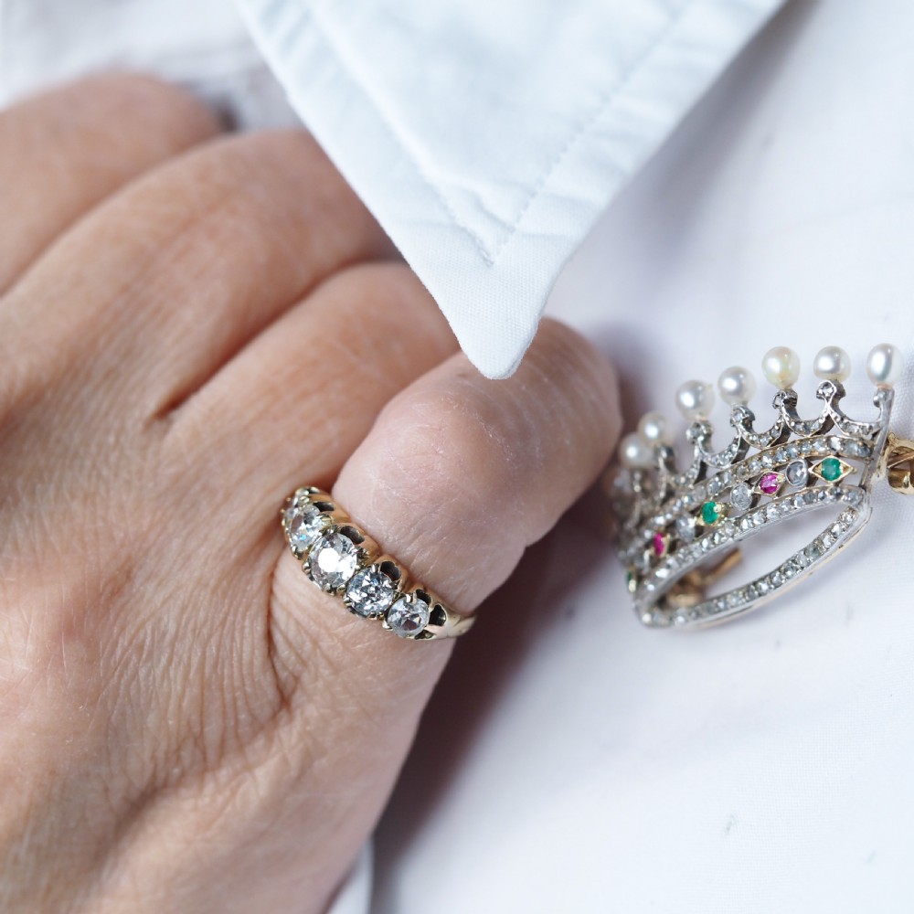 An antique French coronet brooch crafted in 18K gold and silver, encrusted with diamonds, rubies, emeralds, and topped with nine pearls. View VI