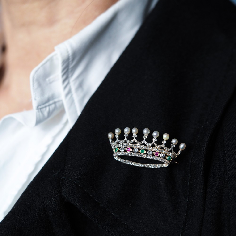 An antique French coronet brooch crafted in 18K gold and silver, encrusted with diamonds, rubies, emeralds, and topped with nine pearls. View VII