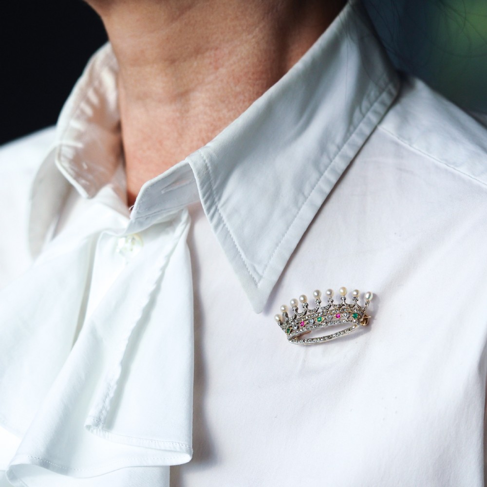 An antique French coronet brooch crafted in 18K gold and silver, encrusted with diamonds, rubies, emeralds, and topped with nine pearls. View IX