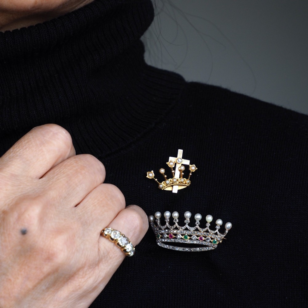 An antique French coronet brooch crafted in 18K gold and silver, encrusted with diamonds, rubies, emeralds, and topped with nine pearls. View X