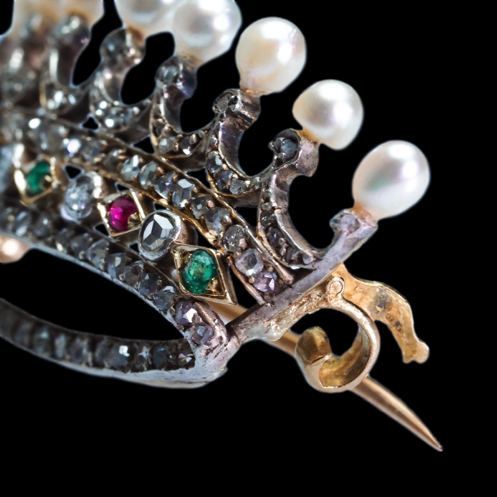 An antique French coronet brooch crafted in 18K gold and silver, encrusted with diamonds, rubies, emeralds, and topped with nine pearls. View XVI