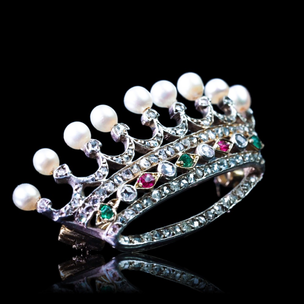 An antique French coronet brooch crafted in 18K gold and silver, encrusted with diamonds, rubies, emeralds, and topped with nine pearls. View XVIII