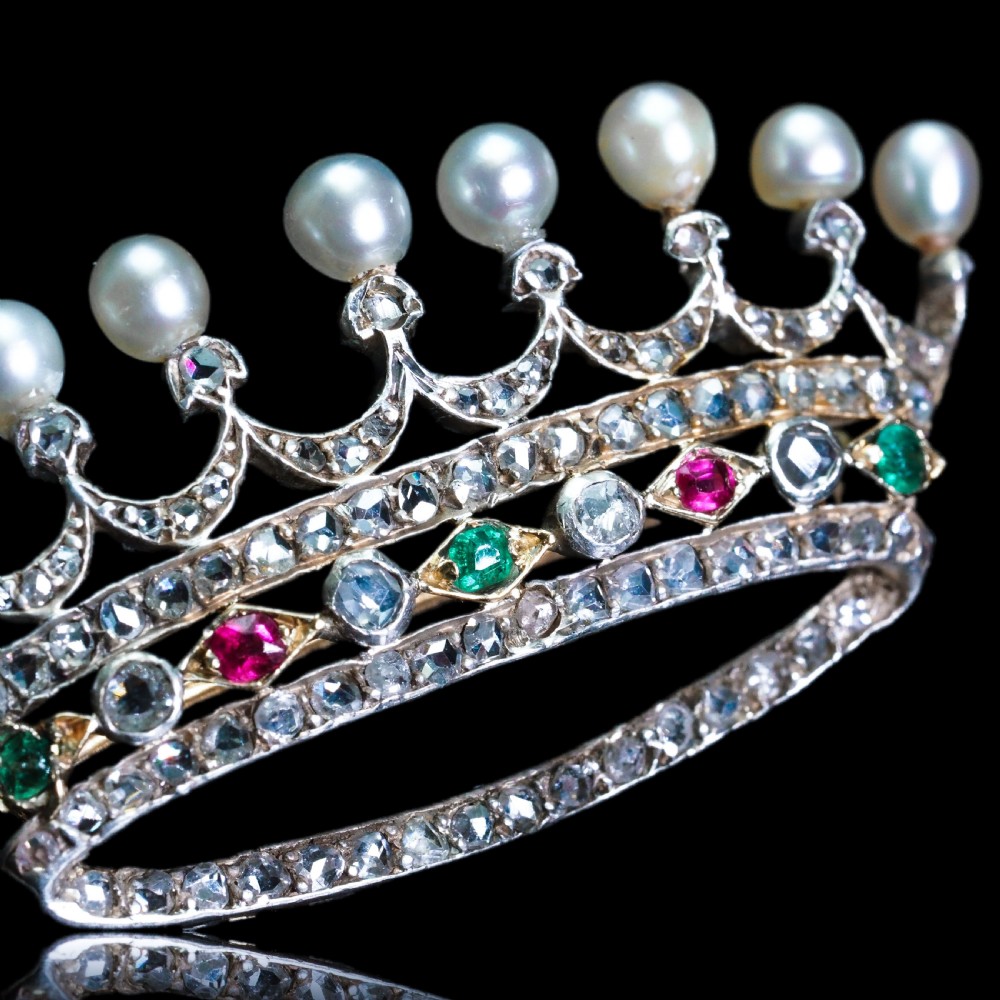 An antique French coronet brooch crafted in 18K gold and silver, encrusted with diamonds, rubies, emeralds, and topped with nine pearls. View XIX
