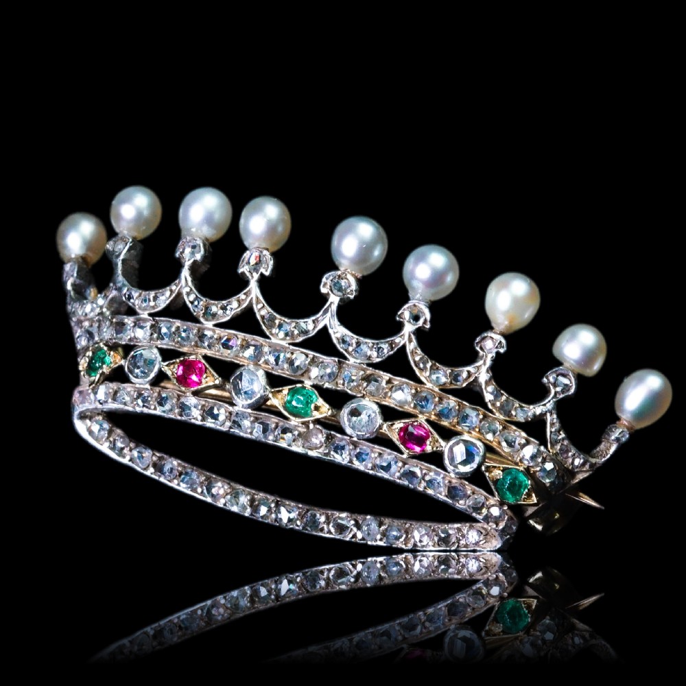 An antique French coronet brooch crafted in 18K gold and silver, encrusted with diamonds, rubies, emeralds, and topped with nine pearls. View XX