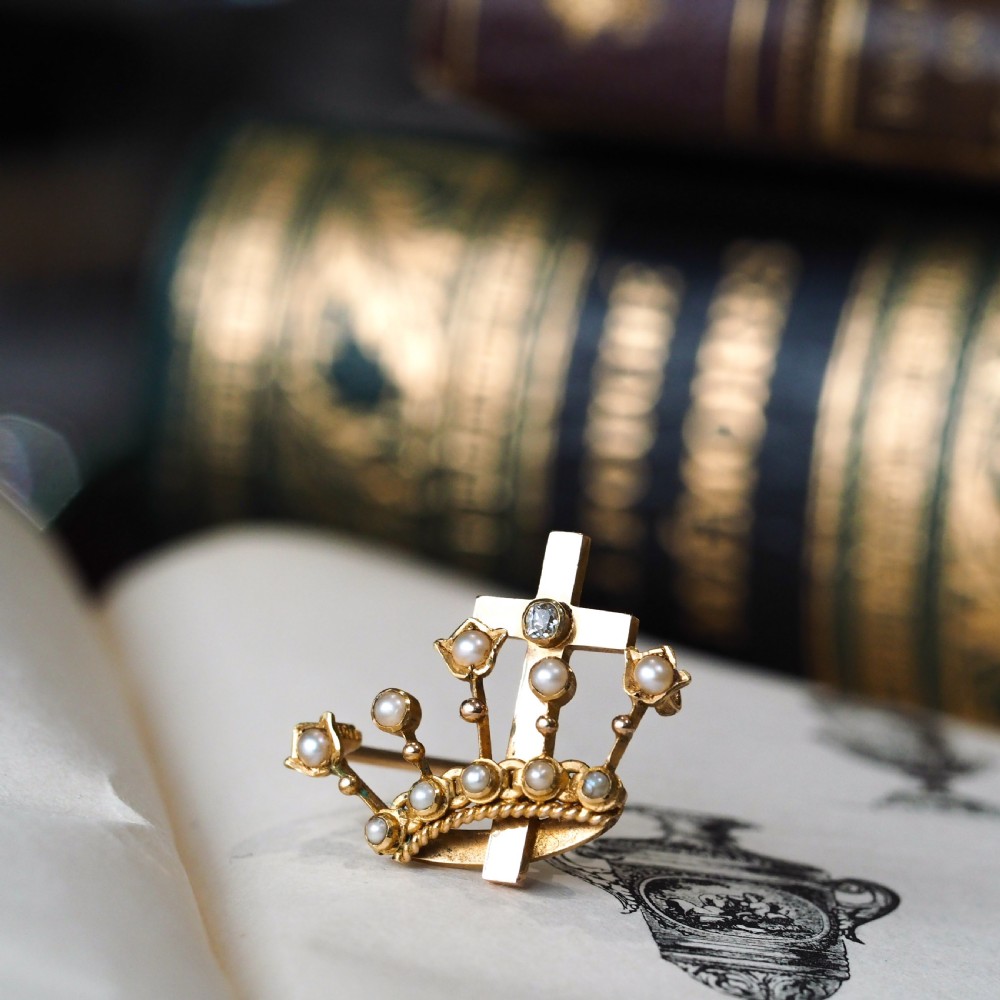 A late Victorian 15-carat gold coronet brooch set with natural pearls and a central cross motif adorned with a single diamond. View XIX