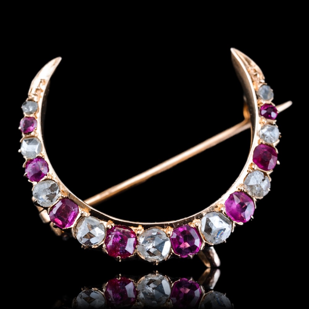 An 18K gold Victorian crescent moon brooch set with alternating cushion-cut rubies and old-cut diamonds. View II